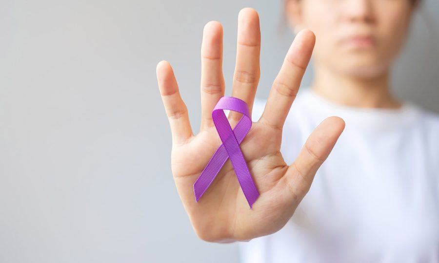 Hand holding purple Ribbon for Pancreatic, Esophageal, Testicular cancer, world Alzheimer, epilepsy, lupus, Sarcoidosis, Fibromyalgia and domestic violence Awareness month. World cancer day concept